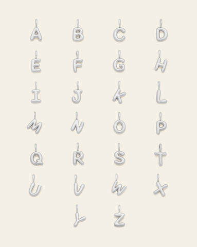 Set of sterling silver puffed letter pendants, featuring the entire alphabet from A to Z, displayed in a grid on a cream background.