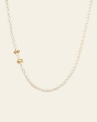 hero image of cord necklace in vanilla paired with gold vermeil chubby spotted spacer and brilliant spacer. 