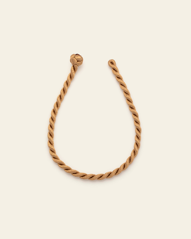 Twisted cord rope bracelet with handcrafted loop knot closure on a neutral background