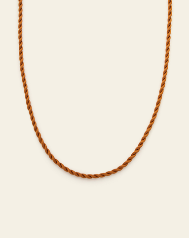 Twisted cord rope necklace with handcrafted loop knot closure on a neutral background in brown caramel colour
