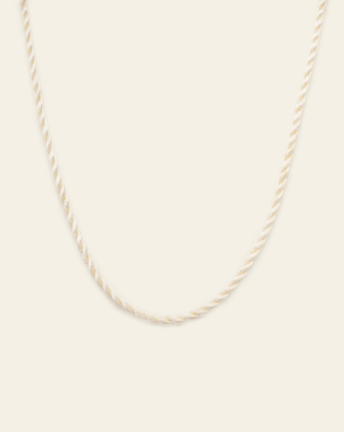 hero image of cord necklace in vanilla on cream background.