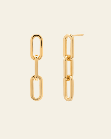 Product image of simple gold link earrings on a cream background.