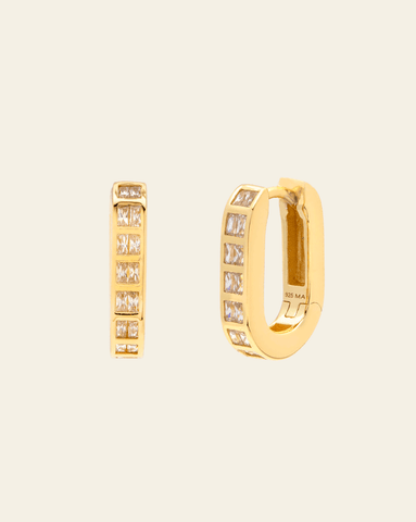 Hero photo of Gold vermeil huggie earrings with channel set square cubic zirconia stones – on cream background