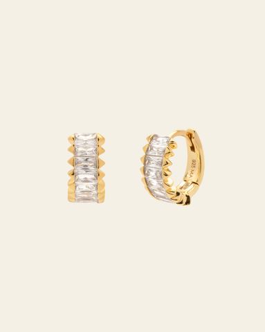 Gold vermeil baguette crystal huggie hoop earrings on beige background