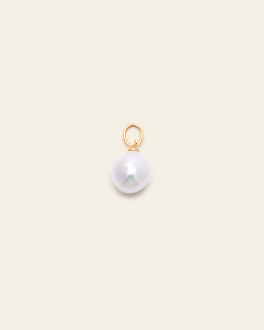A close up photo of a small baroque pearl pendant with a Gold Vermeil jump ring on a cream background. 