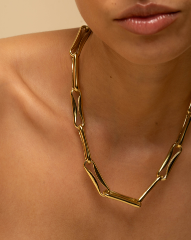 Bold gold-plated statement link necklace on model.