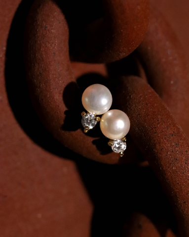 Gold Vermeil Pearl Duo earrings with small  cubic zirconia stones on a textured surface.