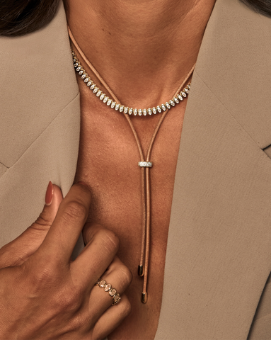 Model is wearing a stack of two necklaces that includes a leather necklace with a gold vermeil pave charm, a gold vermeil oval tennis necklace and a matching gold vermeil oval ring with cubic zirconia.