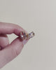 Close-up video of oval stud earrings showing faceted sparkle, shine, and gold prong setting details in natural light.