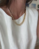 Bold gold-plated statement Figaro link necklace on model.